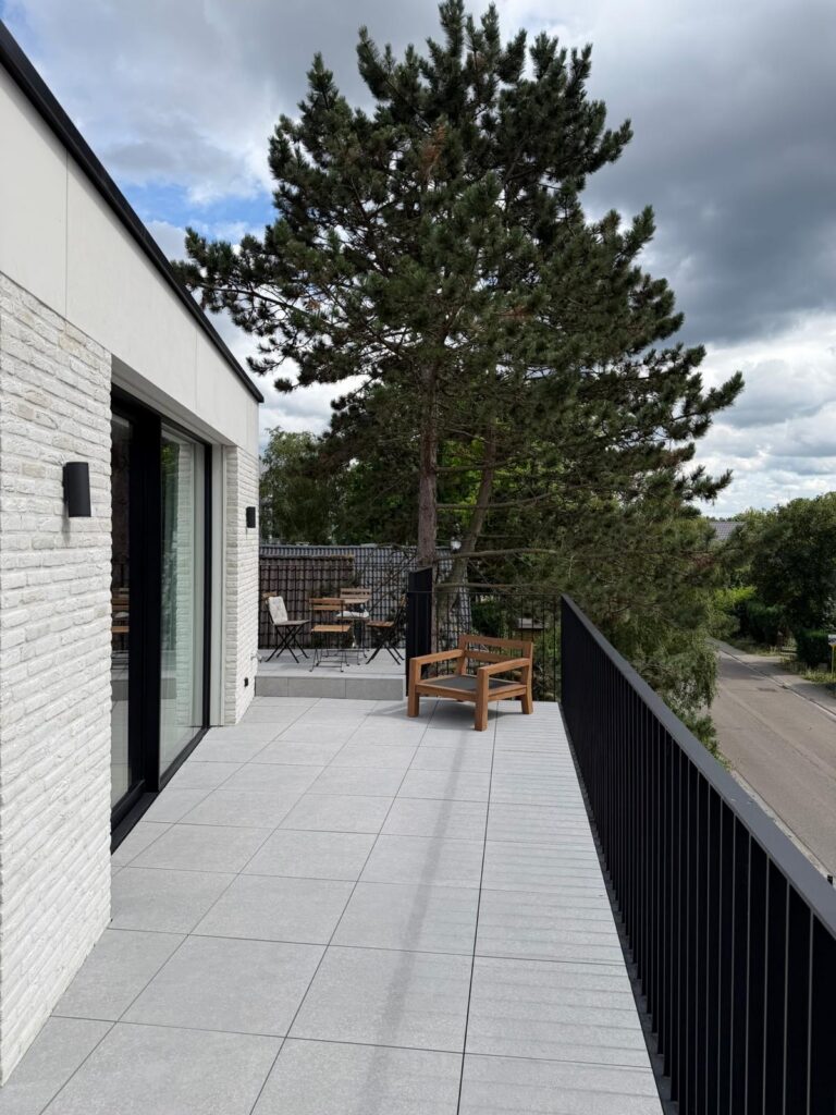 Private apartment terrace with trees behind overlooking a road in Wezembeek-Oppem near Brussels